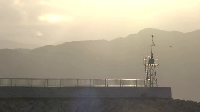 lighthouse at the entrance to the port at first light of dawn
