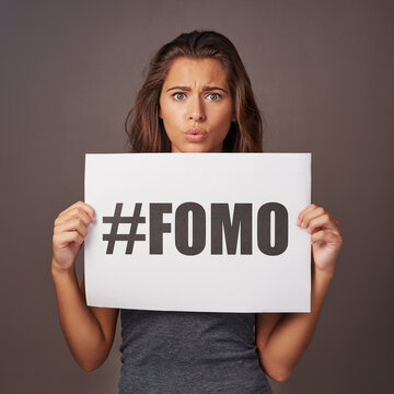 Poster, sign and portrait of woman in studio for information, text and advertising of insecurity. Paper, announcement and female person with anxiety on gray background for fomo, awareness and worry