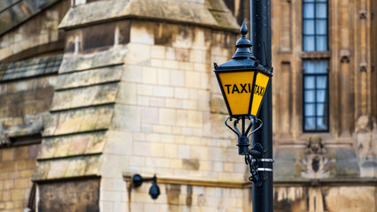 Classic Yellow Taxi Lantern Outside the Historic Houses of Parliament in London