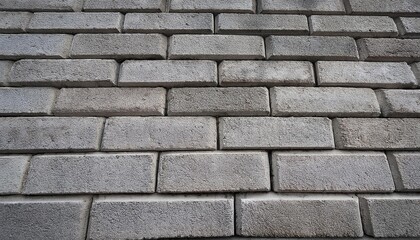 Fototapeta premium A high-resolution texture of a concrete block wall, showcasing the rough surface of the blocks, the mortar lines, and slight variations in color and texture