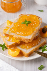 Apricot jam on bread in a white plate