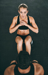 Obraz premium Portrait, fitness and woman for sit ups at gym with personal trainer, core workout and sports exercise of performance. Above, athlete and coach for training support, muscle growth and cardio wellness
