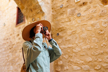 Beautiful woman takes pictures outdoors using an analog camera. travel to Arab countries.