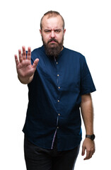 Young caucasian hipster man over isolated background doing stop sing with palm of the hand. Warning expression with negative and serious gesture on the face.