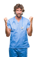 Handsome hispanic surgeon doctor man over isolated background celebrating surprised and amazed for success with arms raised and open eyes. Winner concept.