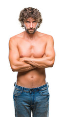 Fototapeta premium Handsome hispanic model man sexy and shirtless over isolated background skeptic and nervous, disapproving expression on face with crossed arms. Negative person.