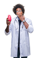 Afro american cardiologist doctor man over isolated background cover mouth with hand shocked with shame for mistake, expression of fear, scared in silence, secret concept