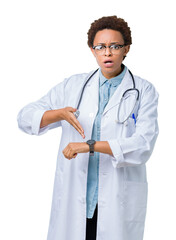 Young african american doctor woman wearing medical coat over isolated background In hurry pointing...