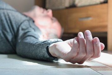 Obraz premium Man lying on the floor at home, epilepsy, unconsciousness, faint, stroke, accident or other health problem
