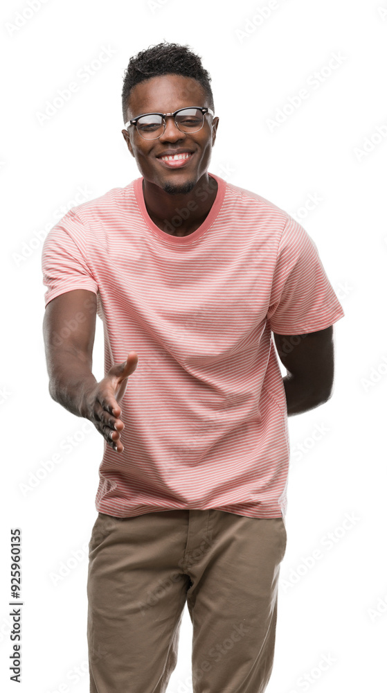 Canvas Prints Young african american man wearing pink t-shirt smiling friendly offering handshake as greeting and welcoming. Successful business.