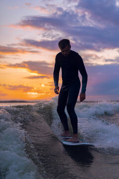Man wakesurfing behind wakeboard boat.