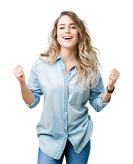 Beautiful young blonde woman over isolated background celebrating surprised and amazed for success with arms raised and open eyes. Winner concept.