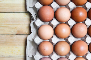 several raw chicken eggs in a cardboard