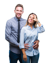 Young workers business couple over isolated background doing ok gesture with hand smiling, eye looking through fingers with happy face.