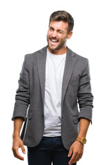 Young handsome business man over isolated background winking looking at the camera with sexy expression, cheerful and happy face.