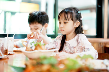 Happy little boy and girl have lunch. Children eating by self. Selective focus.