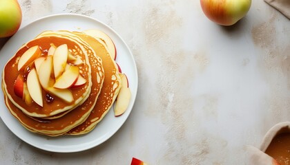 Panqueques con roajas de manzana y jarabe, servidos en un un plato blanco sobre una superficie clara, con espacio disponible para texto a la derecha.