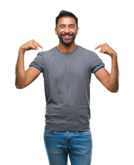 Adult hispanic man over isolated background looking confident with smile on face, pointing oneself...