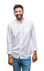 Fototapeta premium Adult hispanic man over isolated background winking looking at the camera with sexy expression, cheerful and happy face.