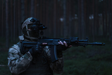 Military special forces with a night vision device in a balaclava with a machine gun with a laser...