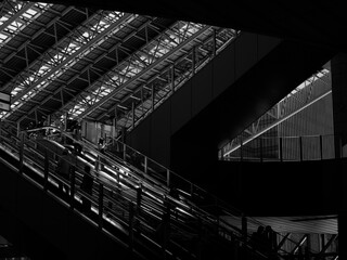 トラス構造の大屋根の下の光があたったエスカレーター