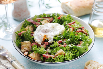 A bowl with salad lyonnaise served for lunch	