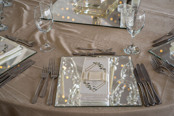 Close-up of a Formal Place Setting Featuring Mirrored Elements and Personalized Details