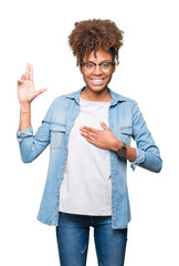 Beautiful young african american woman wearing glasses over isolated background Swearing with hand on chest and fingers, making a loyalty promise oath