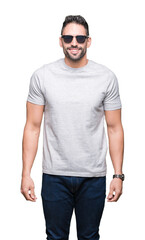 Fototapeta premium Young handsome man wearing sunglasses over isolated background with a happy face standing and smiling with a confident smile showing teeth