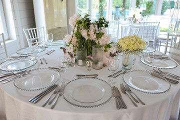 Indoor-Outdoor Event Space with Delicate Floral Arrangements and Place Settings