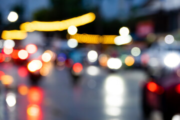 A blurry image of a busy street with cars and motorcycles. The scene is chaotic and busy, with many vehicles moving in different directions. The blurred effect gives the image a sense of motion