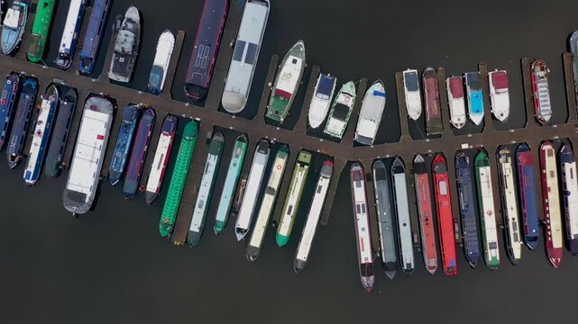 Aerial footage of the area in the Leeds City Centre known as The Leeds Dock showing rows of long boats in the canal