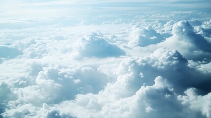 An aerial view of a bright blue sky with soft white clouds.