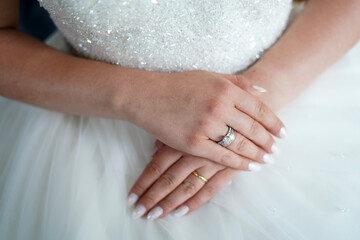 Gentle Touch with Bridal Embellishment: A serene image of hands, softly clasped, with a decorative pearl and white accent wrist piece, conveying refinement and subtle luxury for events