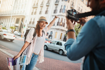 Celebration, photograph and travel with couple in city together for adventure, journey or success. Arm raised, honeymoon and smile of woman with man in urban town for bonding, holiday or vacation