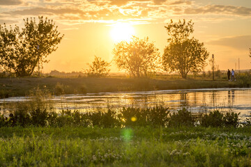 Obraz premium A beautiful sunset over a lake with trees in the background
