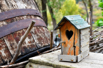 Charming Wooden Birdhouse With Heart Shaped Entrance in a Rustic Outdoor Setting