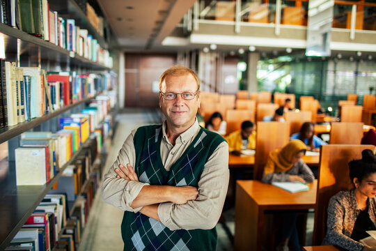 Portrait of a confident middle aged male professor in library
