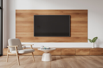 Stylish chill room interior with tv set on drawer, armchair on hardwood floor