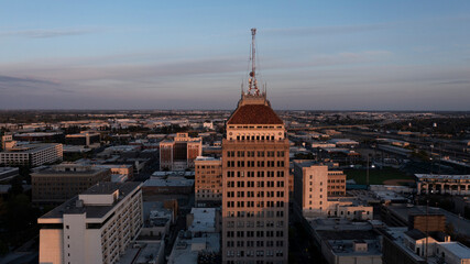 Fototapeta premium Fresno, California, USA - April 18, 2023: Sunset light shines on the historic downtown Fresno skyline.