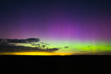 Night starry sky, clouds and northern lights. Nature of Estonia in autumn. View from the Pikanomme observation tower.
