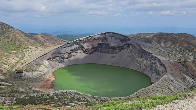 Aerial footage of the volcanic crater lake Okama on the top of Mt. Zao on a sunny day, Japan