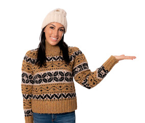 Portrait of a woman in winter clothing showing product with hand isolated over transparent background.