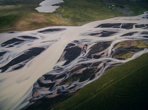 Luftaufnahme einer sich verzweigenden Wildfluss in Island, atemberaubendes Zusammenspiel von Wasser, Sedimenten und Vegetation