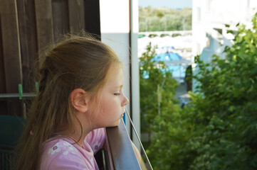 sad girl on the balcony in summer. summer outdoor recreation by the sea.  background for the design.