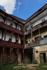 Historical courtyard of traditional buildings in an Eastern European village on a sunny afternoon. Balcony in Romania.