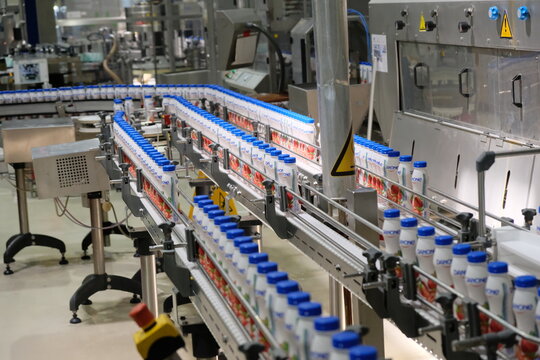 Almaty, Kazakhstan - 07.24.2019 : Conveyor belt with yogurt bottles. The Danone factory.