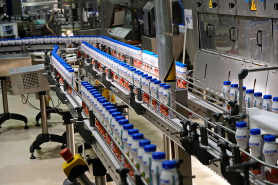 Almaty, Kazakhstan - 07.24.2019 : Conveyor belt with yogurt bottles. The Danone factory.