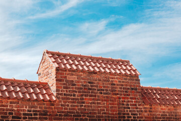Naklejka premium medieval red brick wall with new roof tiles 