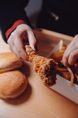 close up focus woman hand hold fried chicken for eat,girl with fast food concept